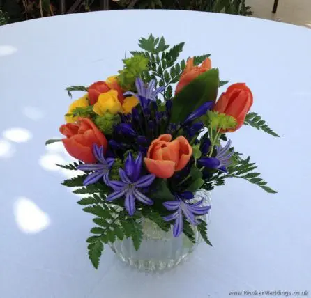 Brightly Coloured Jars of Flowers Reception Table Arrangements in Primary Colours with Tulips, Agapanthus and Spray Roses at The Palm House, Sefton