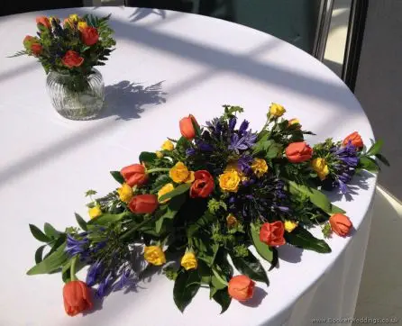 Brightly Coloured Reception Table Arrangements in Primary Colours with Tulips, Agapanthus and Spray Roses at The Palm House, Sefton