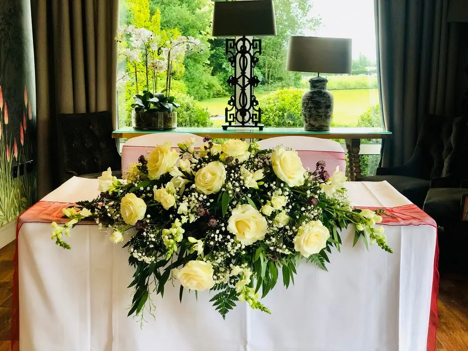 Wedding Table Arrangement In White Roses and Gypsophila