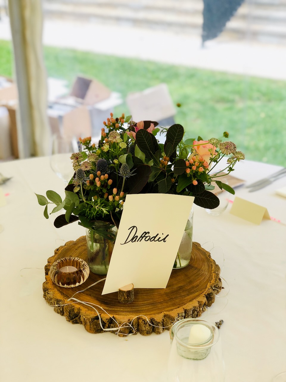 Garden Style Jam Jars of Flowers on Log Slice