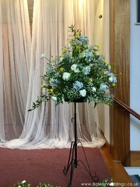 Pedestal arrangement in blue and white on stand for church or reception