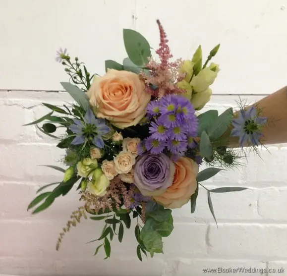 Wild Garden Hand Tied Bridesmaid Bouquet in Peach, purples and blues with roses, spray roses, astilbe, lissianthus, nigella, september flower and daisies