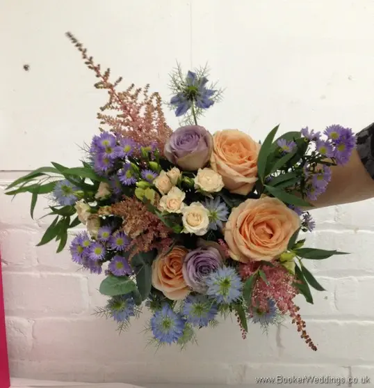 Wild Garden Themed Hand Tied Bridal Bouquet in Peach, purples and blues with roses, spray roses, astilbe, lissianthus, nigella, september flower and daisies