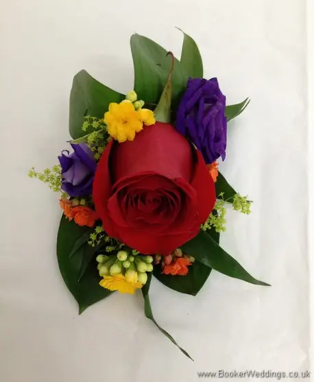 Bright and vibrant pin corsage featuring rose, lissianthus and alchamelia molis