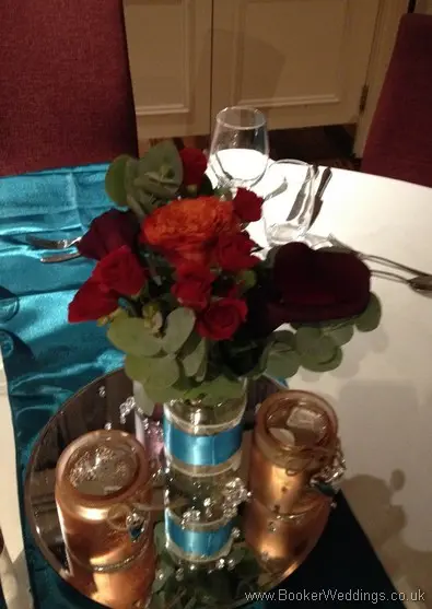 4 jar table arrangement in orange, raspberry & dark red with roses, spray roses and calla lillies at Hard Days Night Hotel Liverpool