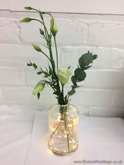 Cream Lissianthus in a lit up bottle table centrepiece