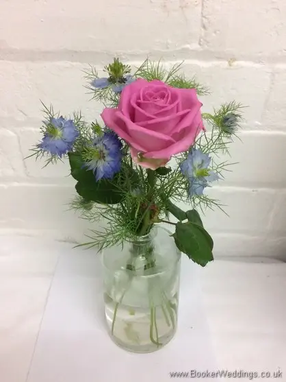 Pink rose and blue nigella bottle table decoration