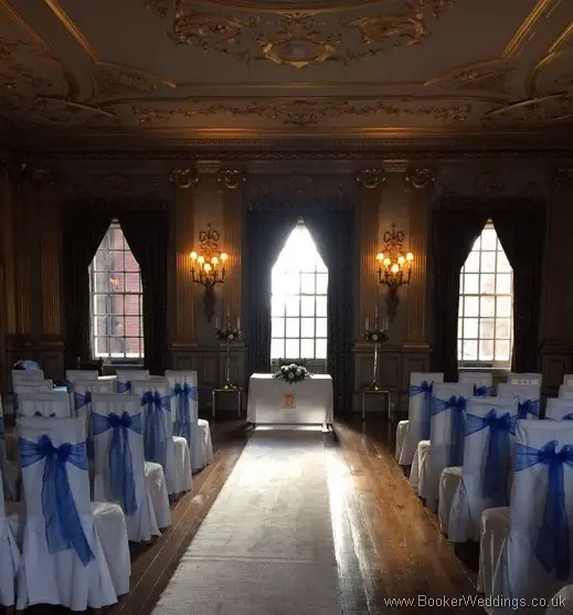 White and blue registrars table arrangement with calla lillies and blue chair covers at Knowsley Hall