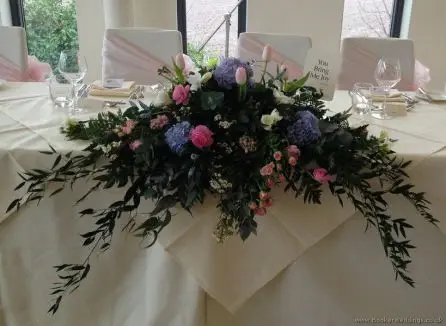Pink and Blue Low and Long Top Table Arrangement with Hydrangea, Ranunculus, Freesia, Muscari, Tulips, Spray Roses and Hyacinth