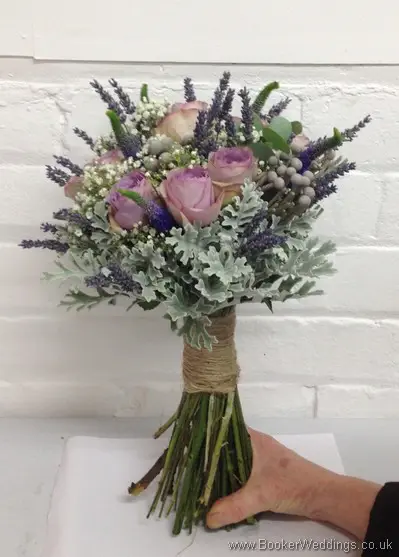 Just Picked but Neat Hand Tied Bridal Bouquet of Lilac Rose, Veronica, Gypsy Grass, Brunia Berries, Grey Senecio Leaves and Lavender tied with twine Side View