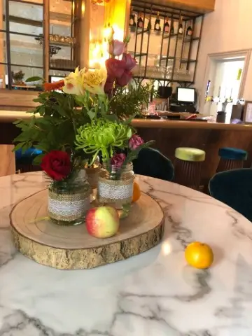 Bright Flowers And Fruit In Jam Jars And Log Slices