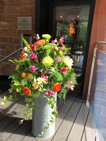 Vibrant And Bright Milk Churn Entrance Flowers