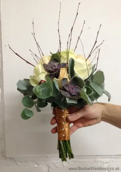 Winter woodland themed wedding Bridal bouquet with Cream avalanche & peach roses, burgundy succulents, copper cones & twigs Side View