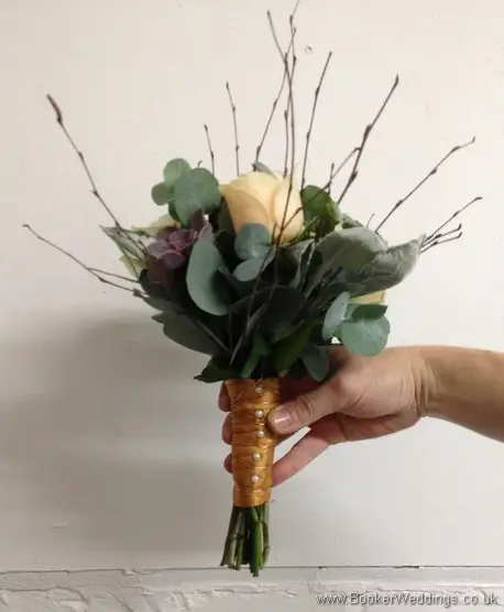 Winter woodland themed wedding Bridesmaid bouquet with Cream avalanche & peach roses, burgundy succulents, copper cones & twigs Side View