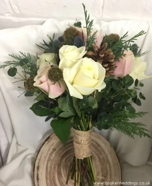Rustic winter wonderland bridesmaid bouquet of blush and ivory roses, eryngium, scabisoa, pine cones, eucalyptus and spruce