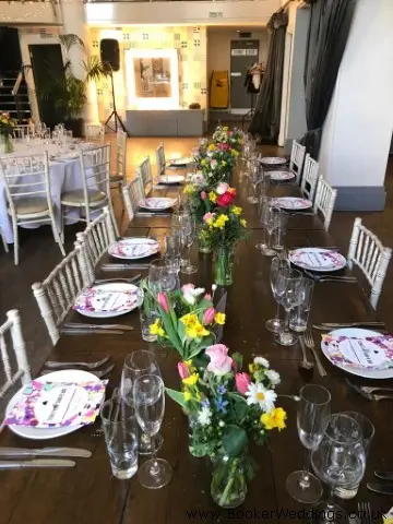 Bright Flowers In Jars On Top Table