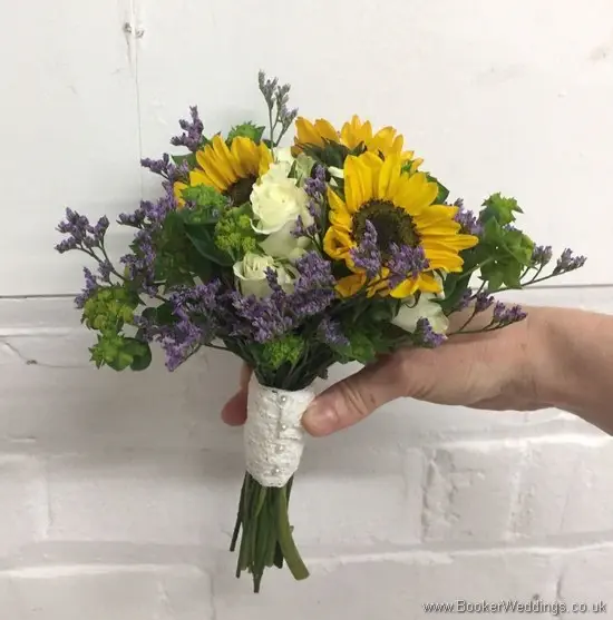 Mini Flowergirl handtied bouquet with yellow gerberas, white spray roses, purple limoneum and purple lissianthus side view