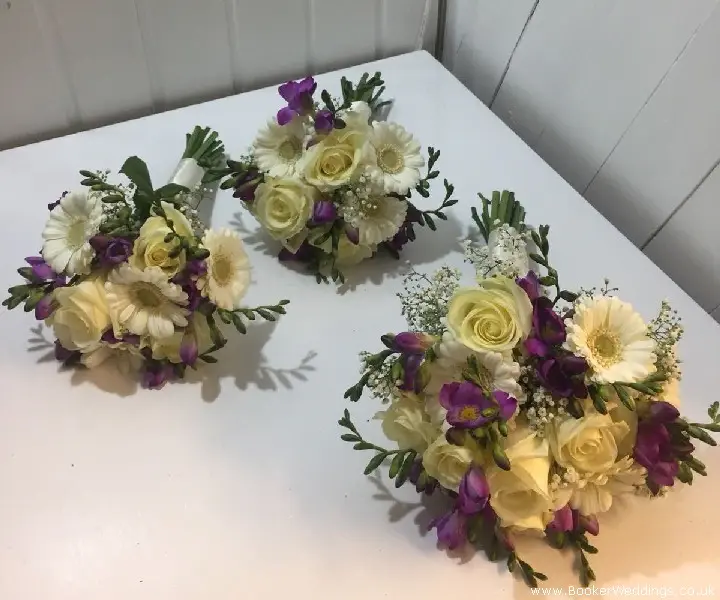 white and purple bride and bridesmaids bouquets featuring gerberas roses and freesia