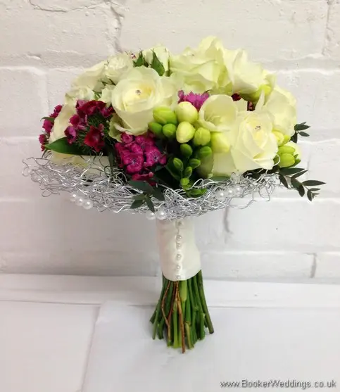 Bridal hand tied bouquet featuring Roses and Spray Roses, Freesia and Sweet William caged in silver wire and pearls with diamante in the roses side view