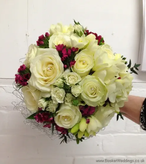 Bridal hand tied bouquet featuring Roses and Spray Roses, Freesia and Sweet William caged in silver wire and pearls with diamante in the roses