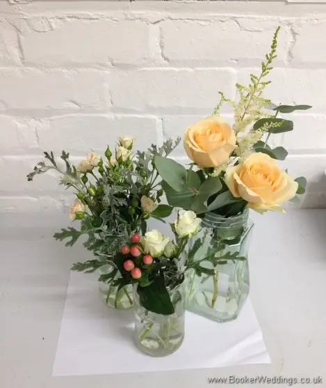 Peaches and Cream Country Garden Flowers Jam jar table centrepieces with roses, spray roses, astilbe, hypernicum berries & grey senicio leaves