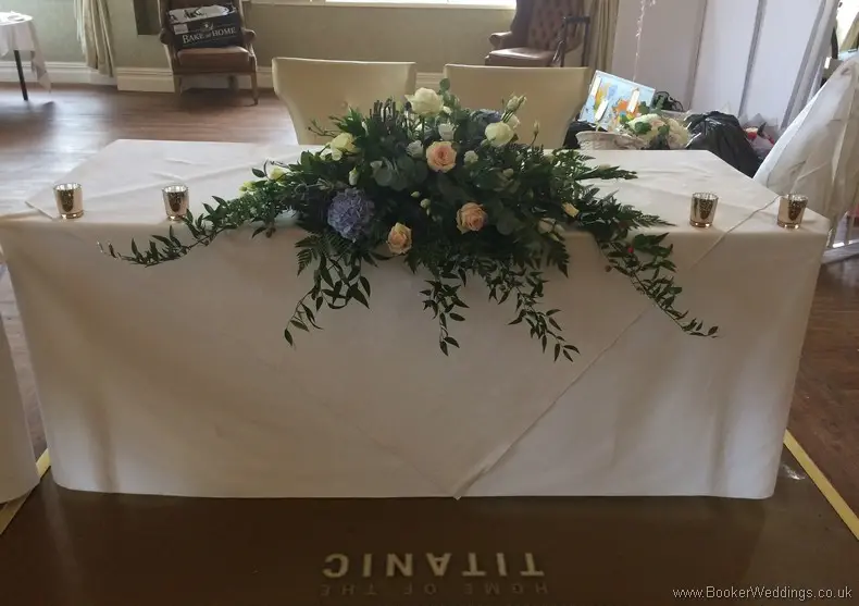Long and Low Registrar Table Arrangement of Blue Hydrangea, Creams and Blush Pink roses Front View