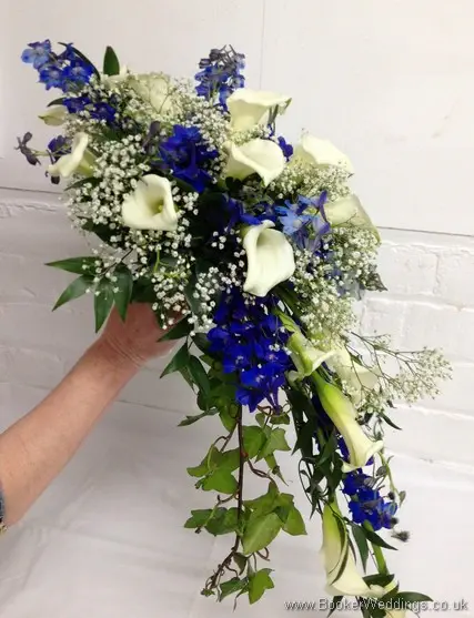 Bridal teardrop shower bouquet featuring white calla lillies, blue delphinium and gypsy grass right view
