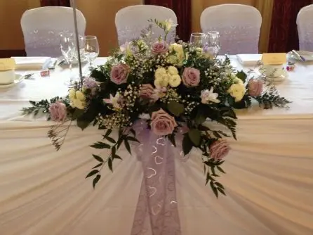 Lilac and cream rose and freesia top table arrangement close up