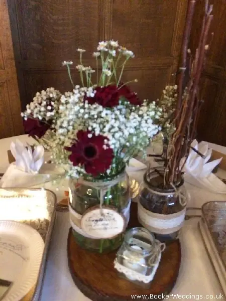 wedding table centrepieces jam jars of gerbera gypsy grass and daisys